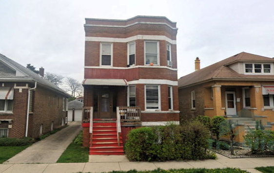A brick house with red stairs in front of it