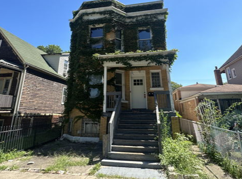A house with ivy growing on it and stairs leading up to it