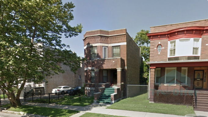 Two brick houses are next to each other on a residential street