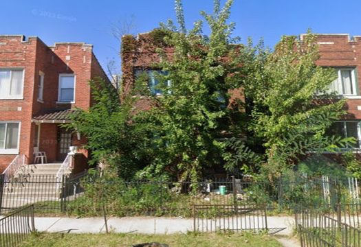 A brick building with a tree in front of it