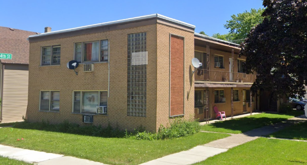 A brick apartment building with a satellite dish on the side of it