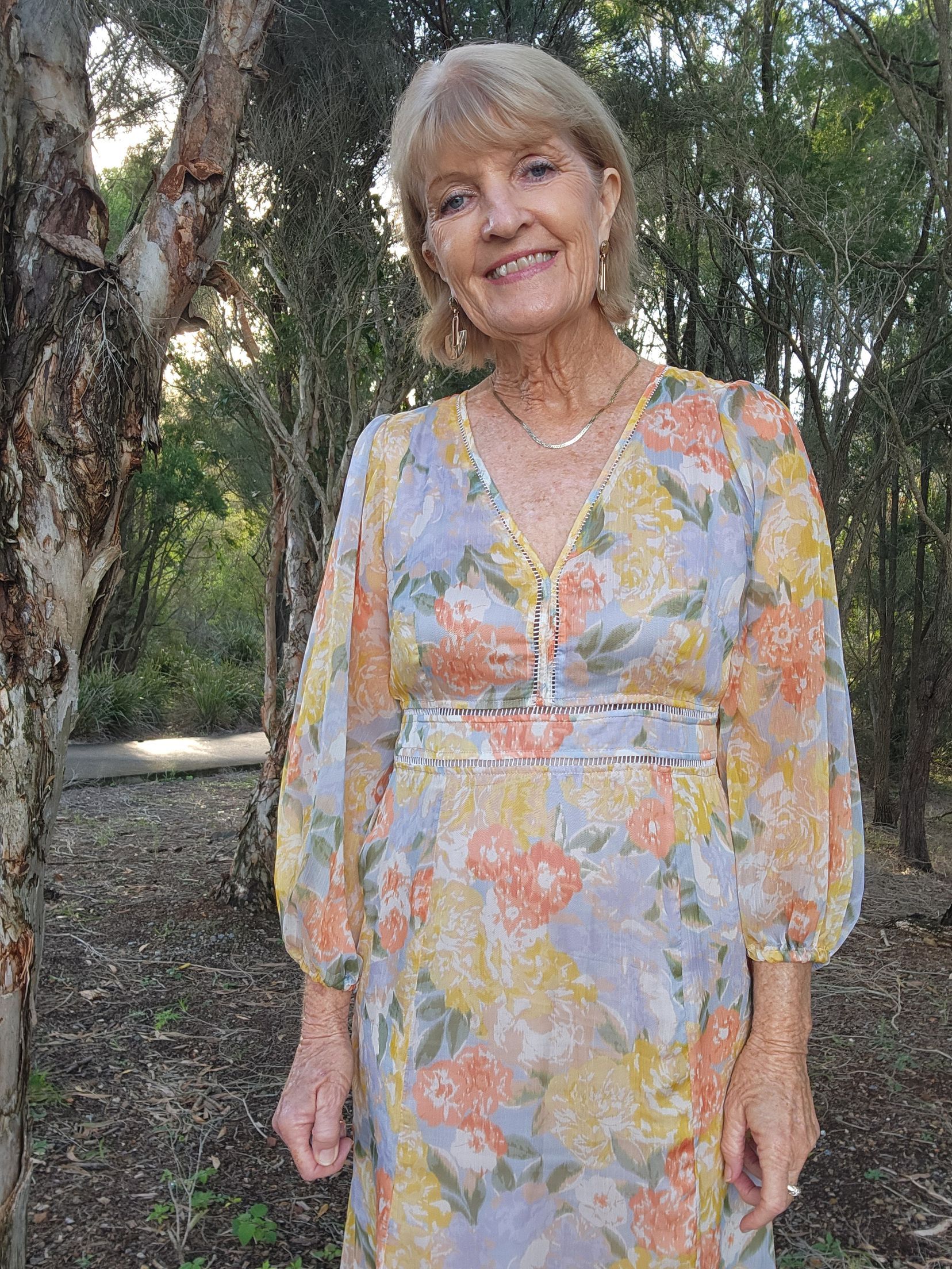 A Woman in A Dress Is Holding a Tablet and Smiling — Vivienne Celebrant - Gold Coast Wedding Celebrant in Mudgeeraba, QLD