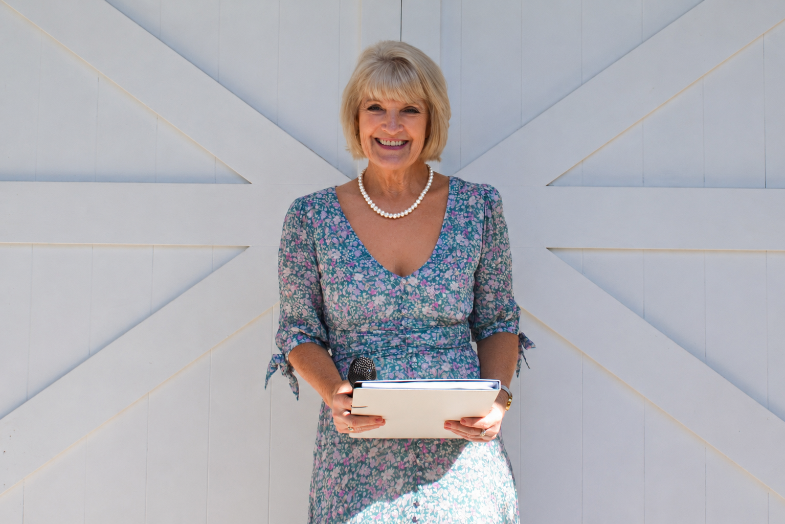 A Woman in A Dress Is Holding a Tablet and Smiling — Vivienne Celebrant - Gold Coast Wedding Celebrant in Mudgeeraba, QLD