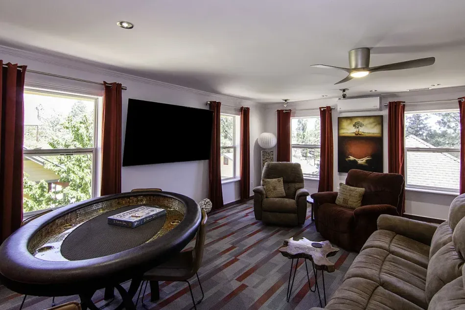 Modern living room with recliners, sectional sofa, large TV, and bright windows