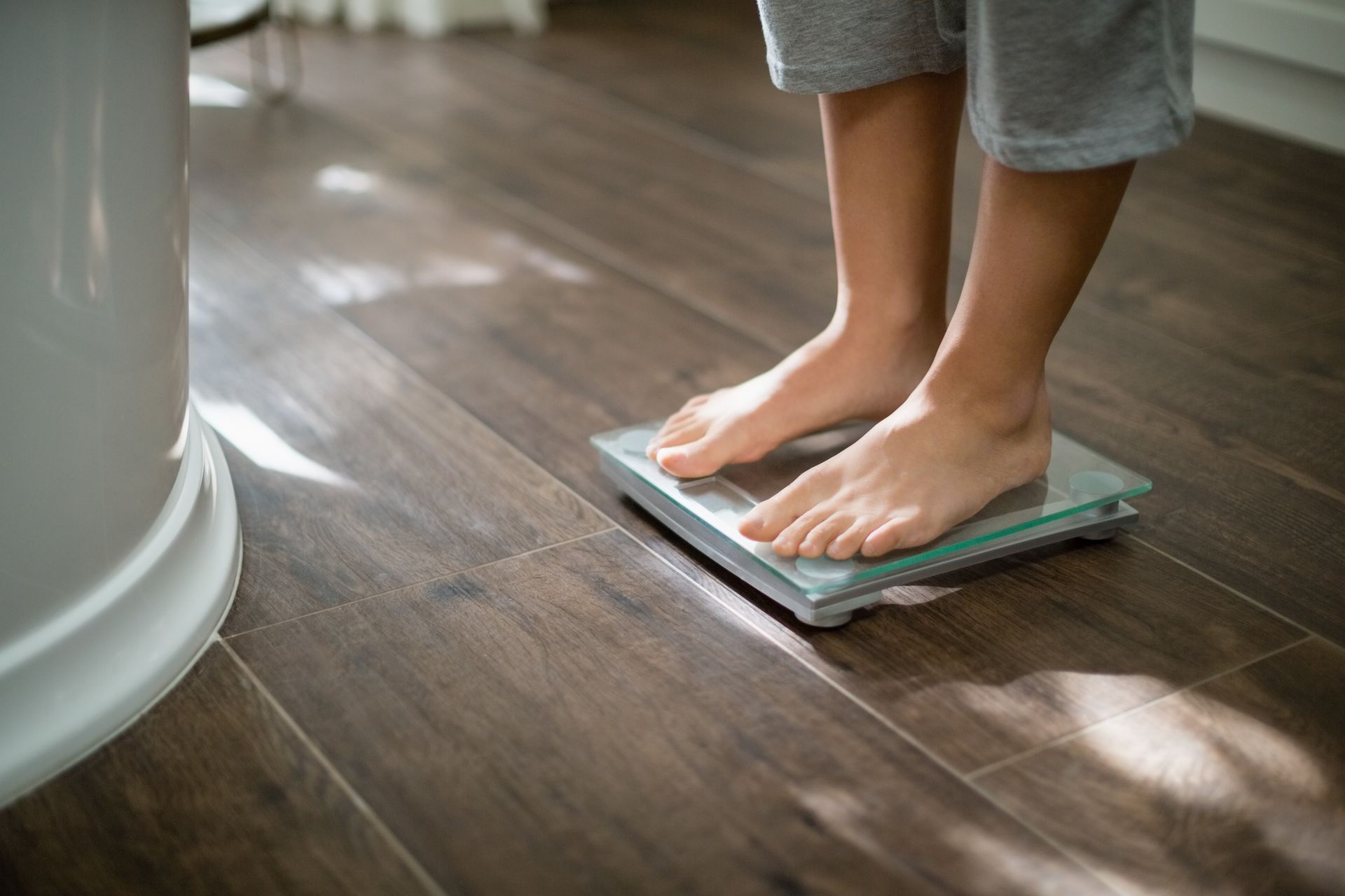 A person is at a weight scale.