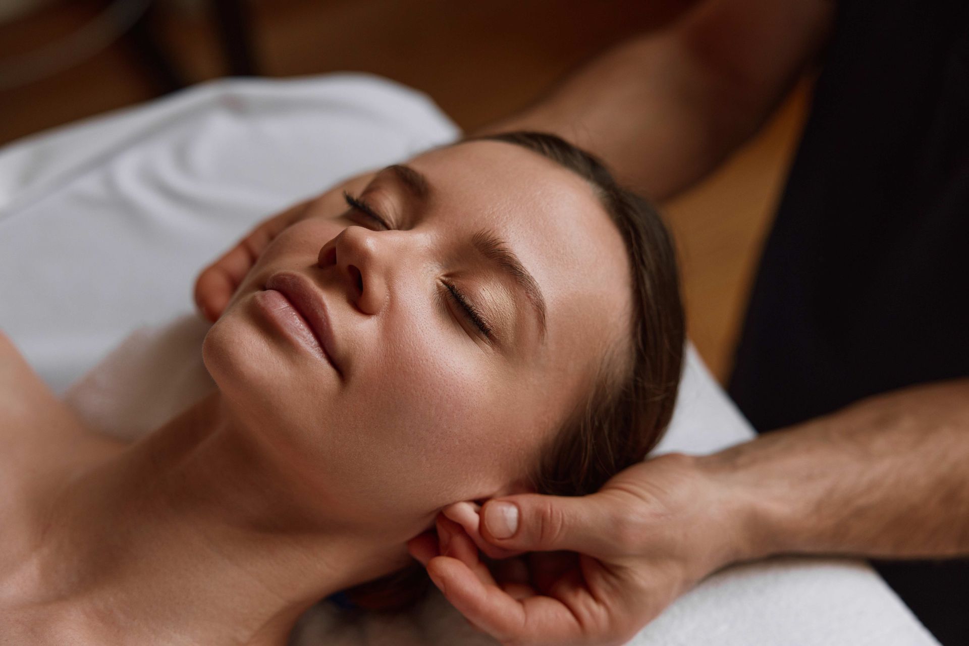 Peaceful female face at massage session in spa center. Peaceful female face at massage session in spa center.