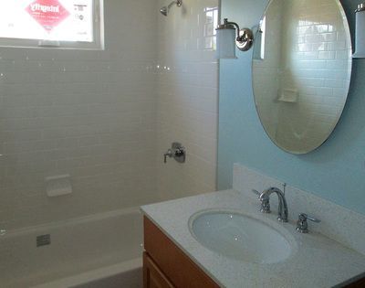 A bathroom with a sink , tub and mirror
