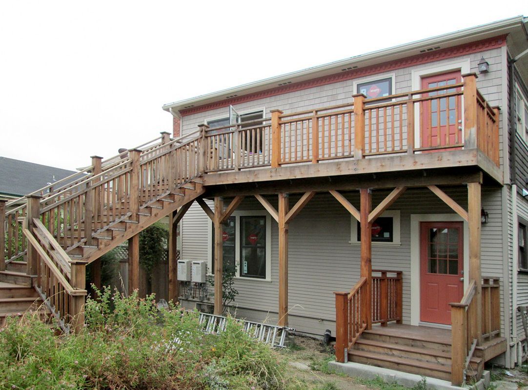 A house with a wooden deck and stairs leading up to it.