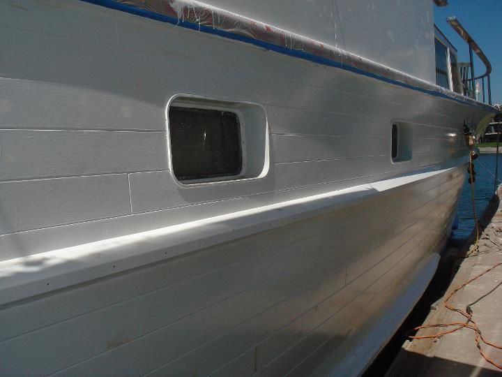 A large white boat is docked at a dock