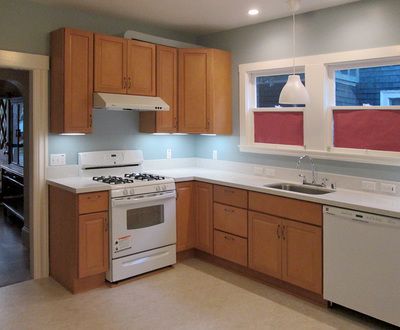 A kitchen with wooden cabinets and a white stove