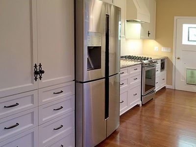 A kitchen with stainless steel appliances and white cabinets