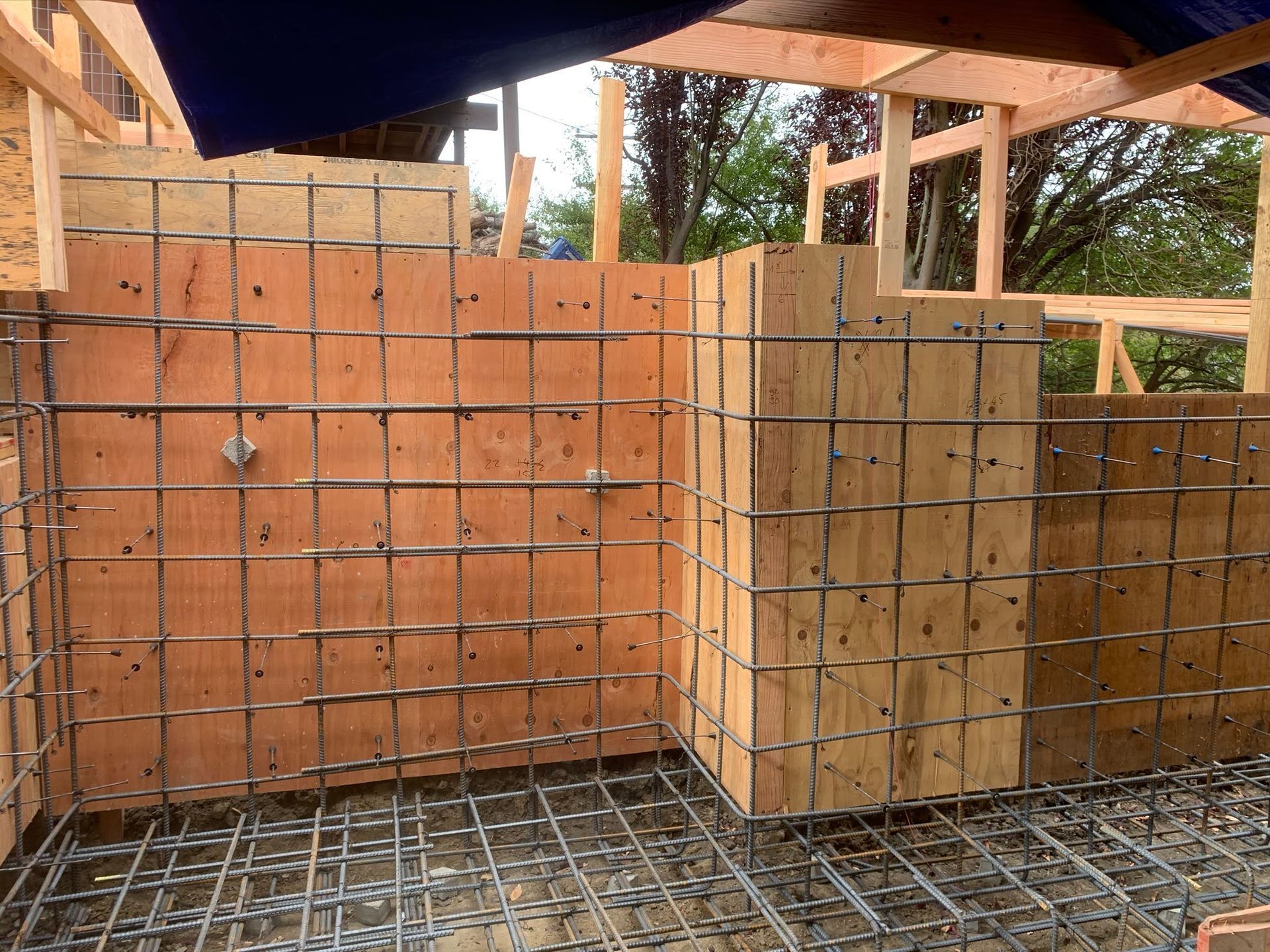 Rebar and plywood forms for concrete walls and floor slab at a construction site
