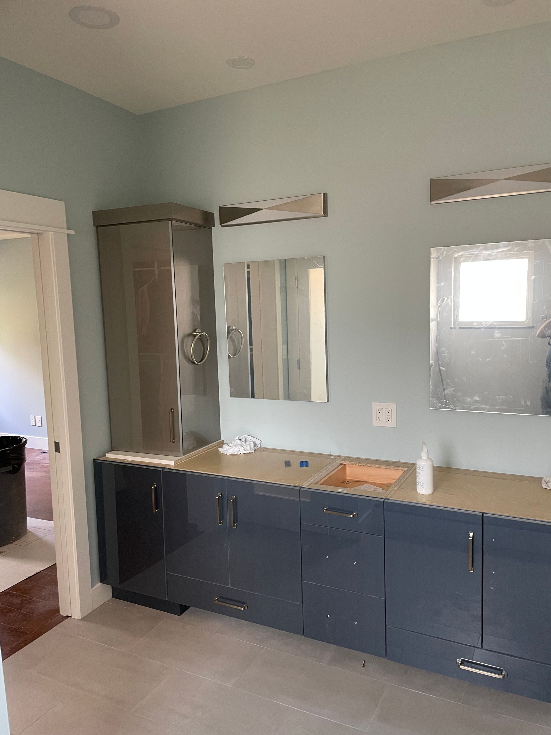 Modern bathroom vanity with dark cabinets, mirror, and gray walls