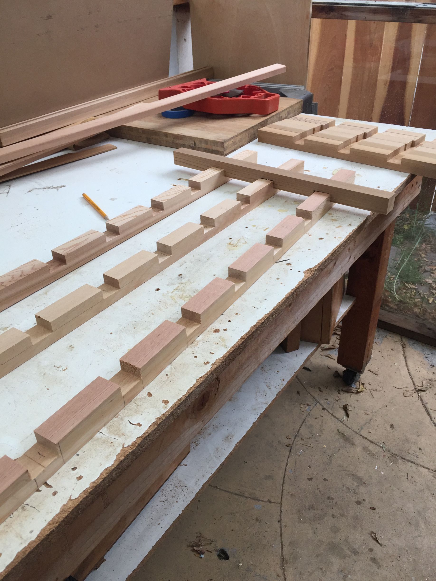 Wooden slatted frame with evenly spaced blocks on a workbench in a workshop or garage