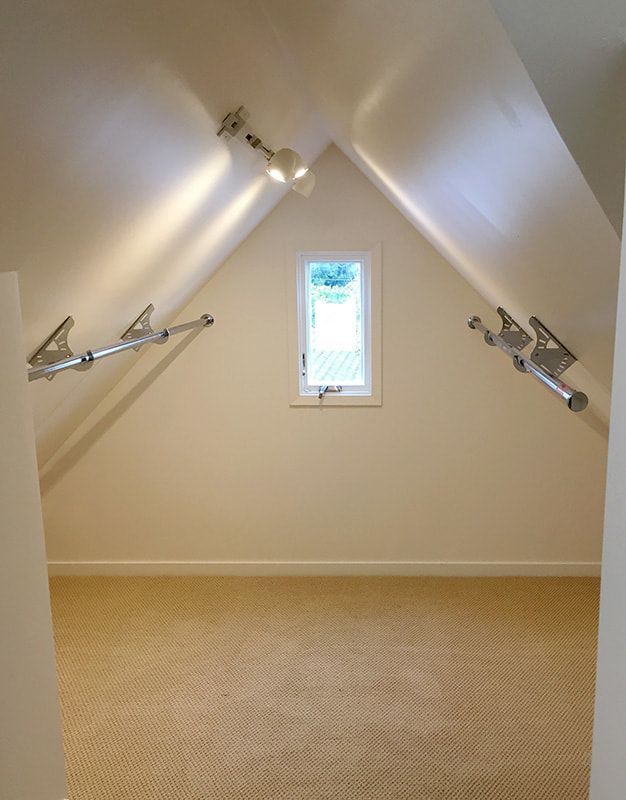 An empty room with a window and a vaulted ceiling