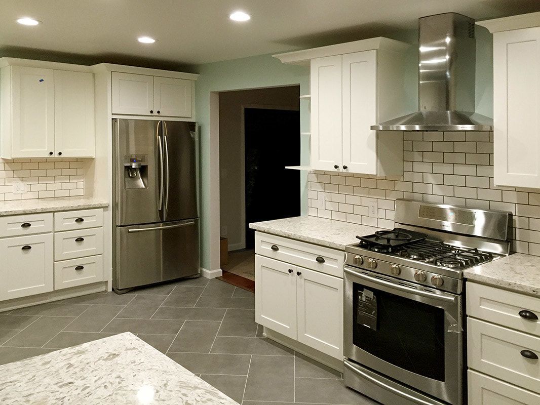 A kitchen with stainless steel appliances and white cabinets
