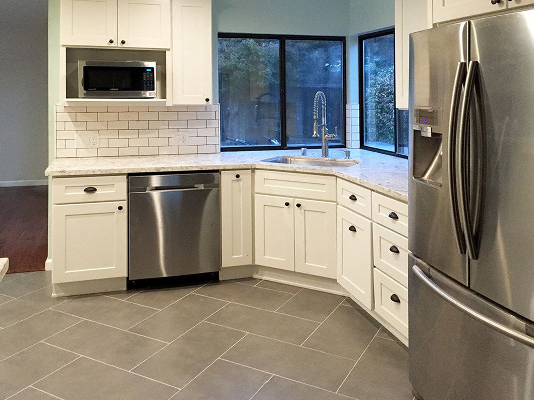 A kitchen with stainless steel appliances and white cabinets