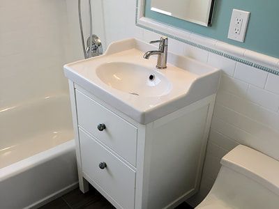 A bathroom with a sink , toilet , bathtub and mirror.