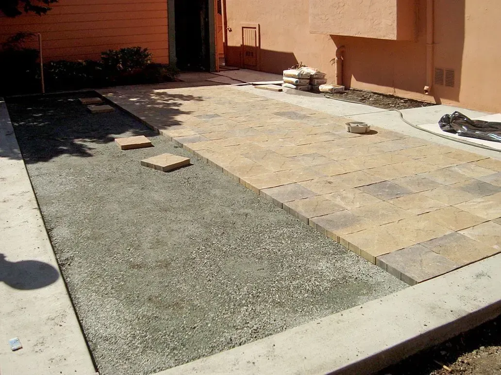 Natural stone pavers being installed over a gravel base in a Richmond backyard outdoor living space