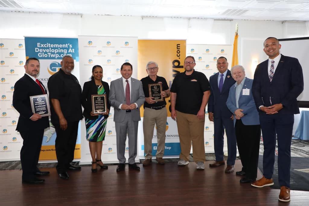 A group of people standing next to each other holding awards.