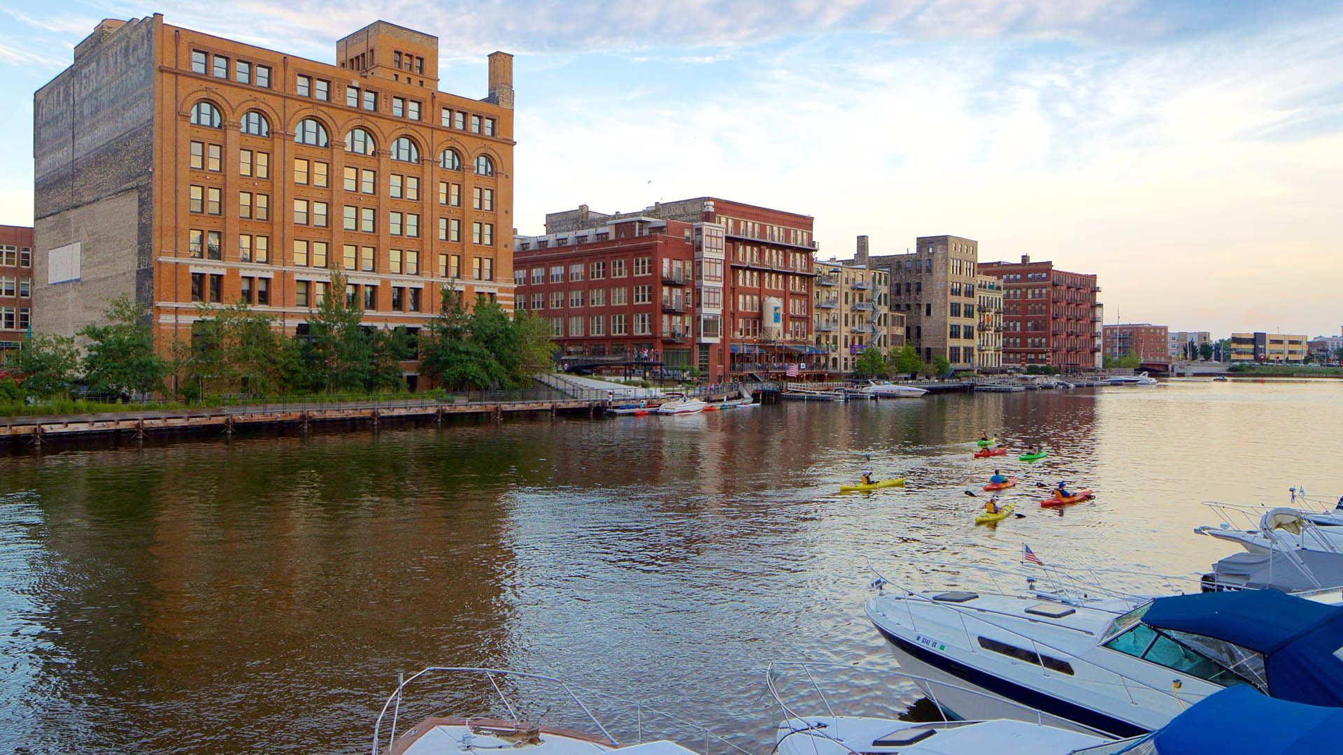 Group kayaking on the Milwaukee River with the downtown skyline in the background.