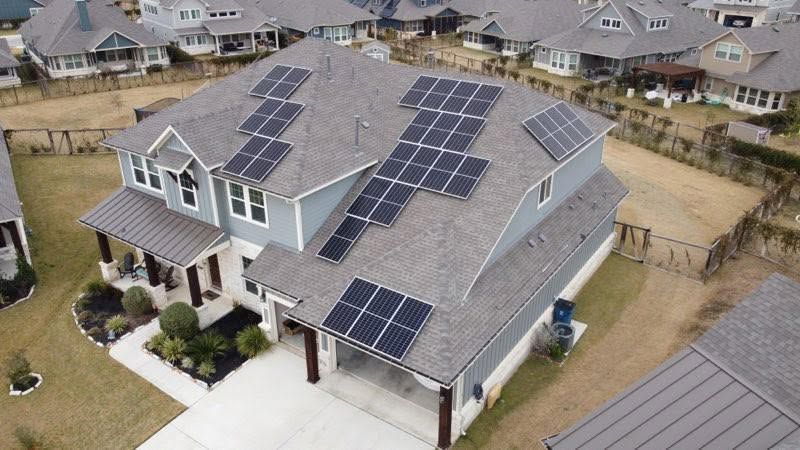 Aerial view of a suburban house roof covered with solar panels