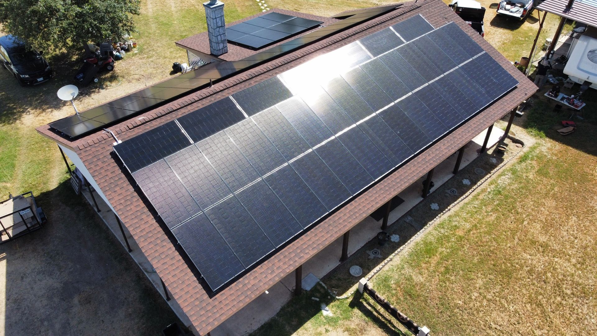 Aerial view of a house roof covered with large black solar panels.