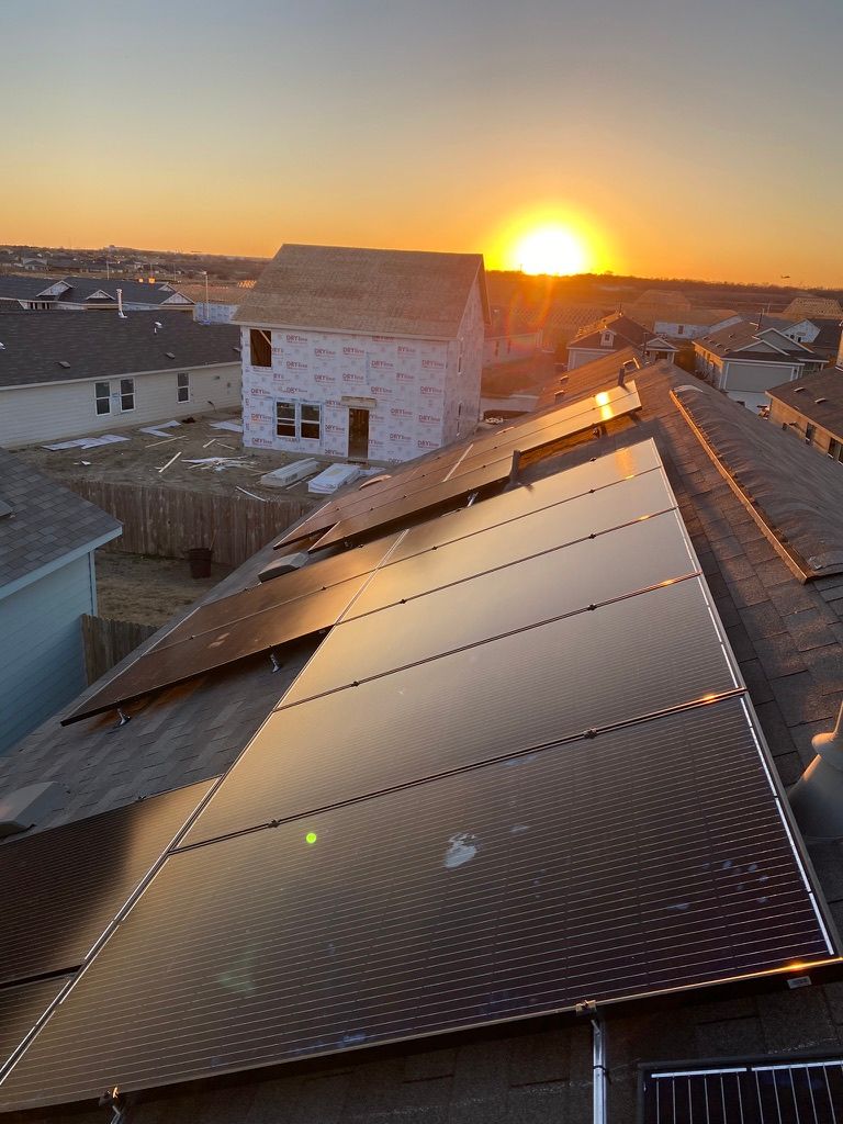 Sunset over rooftop solar panels in a suburban neighborhood