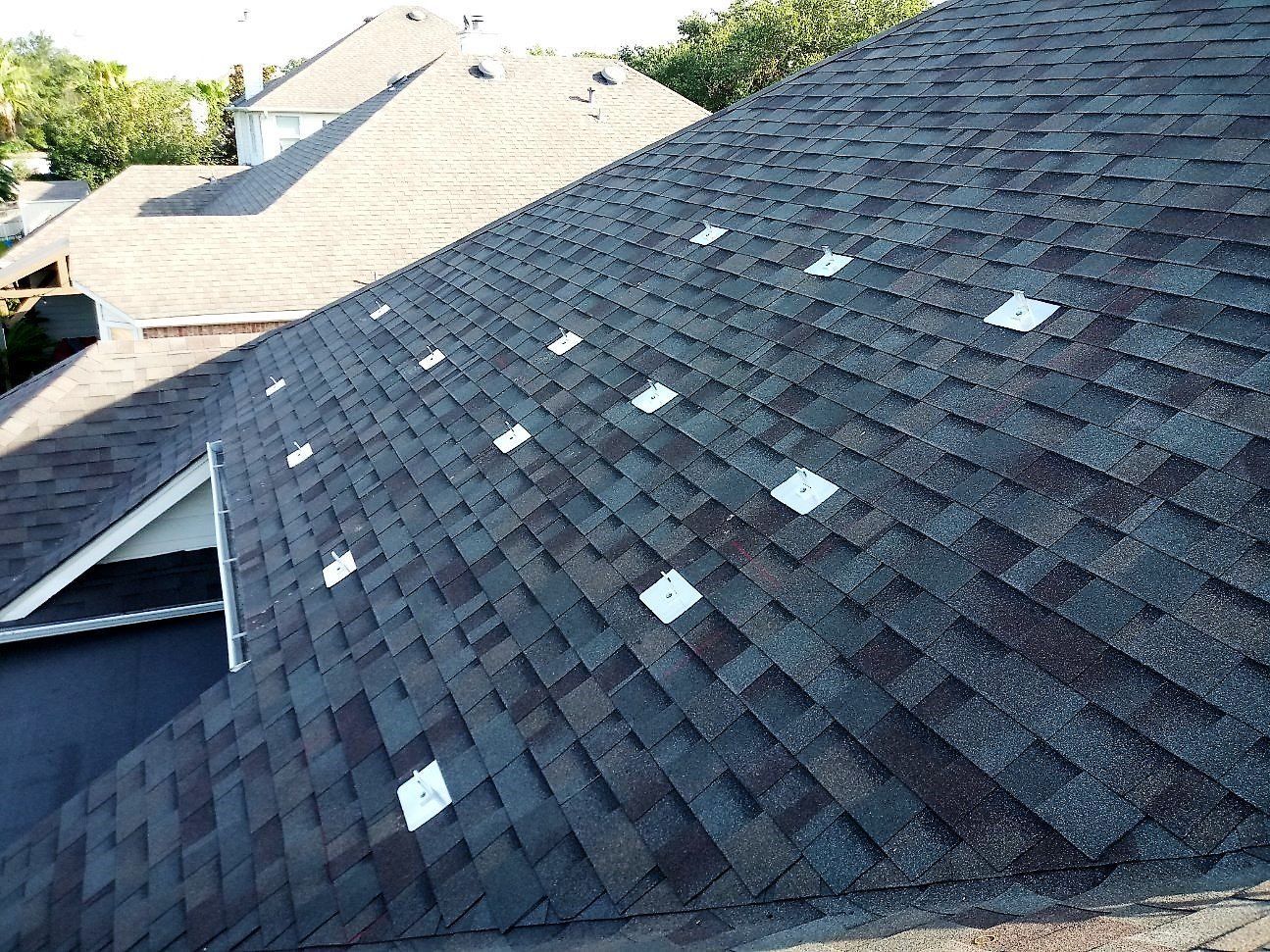 Dark shingled roof with scattered white patches, viewed from above