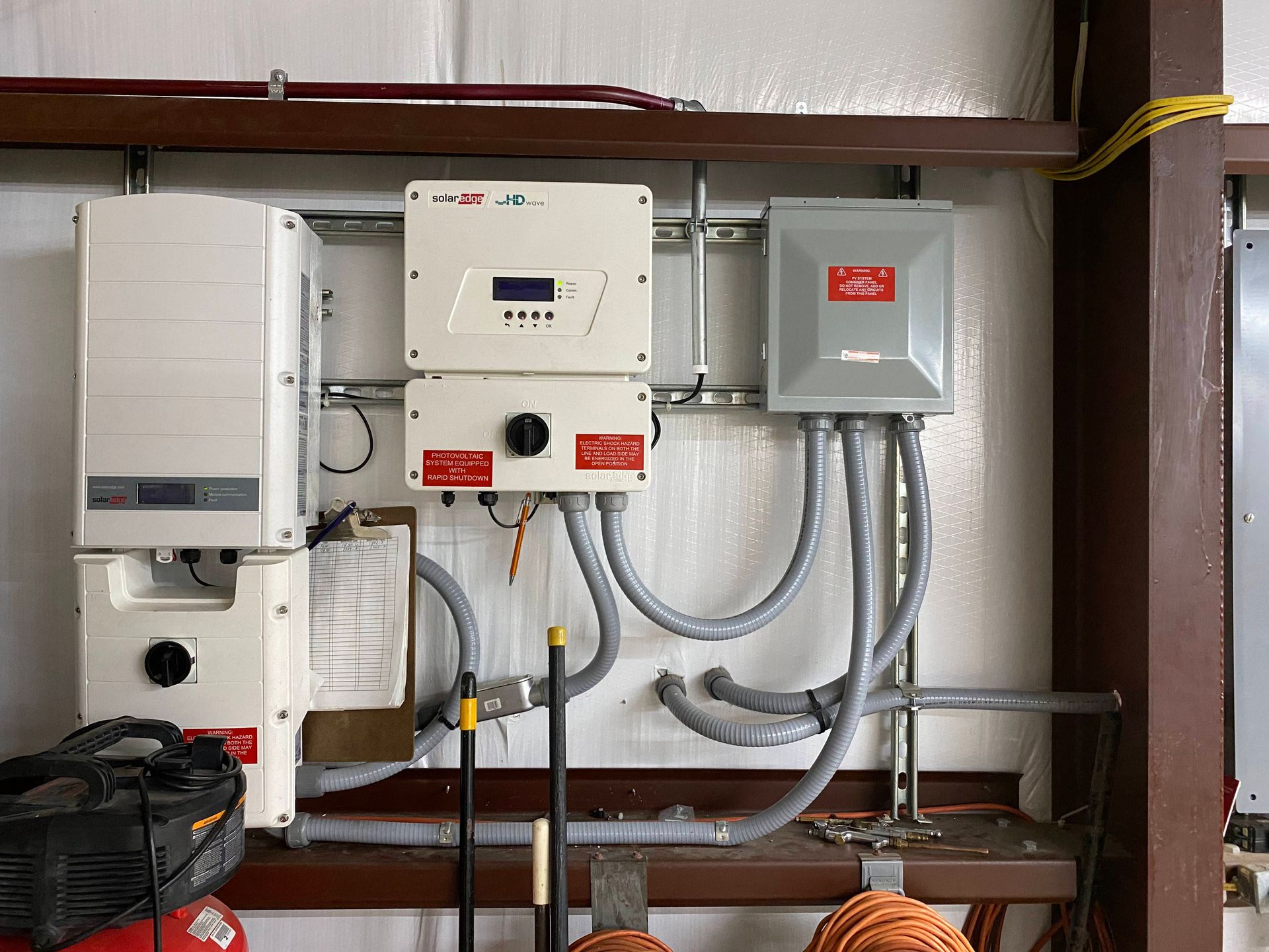 Utility control panels and wiring mounted on shelves in a small equipment room