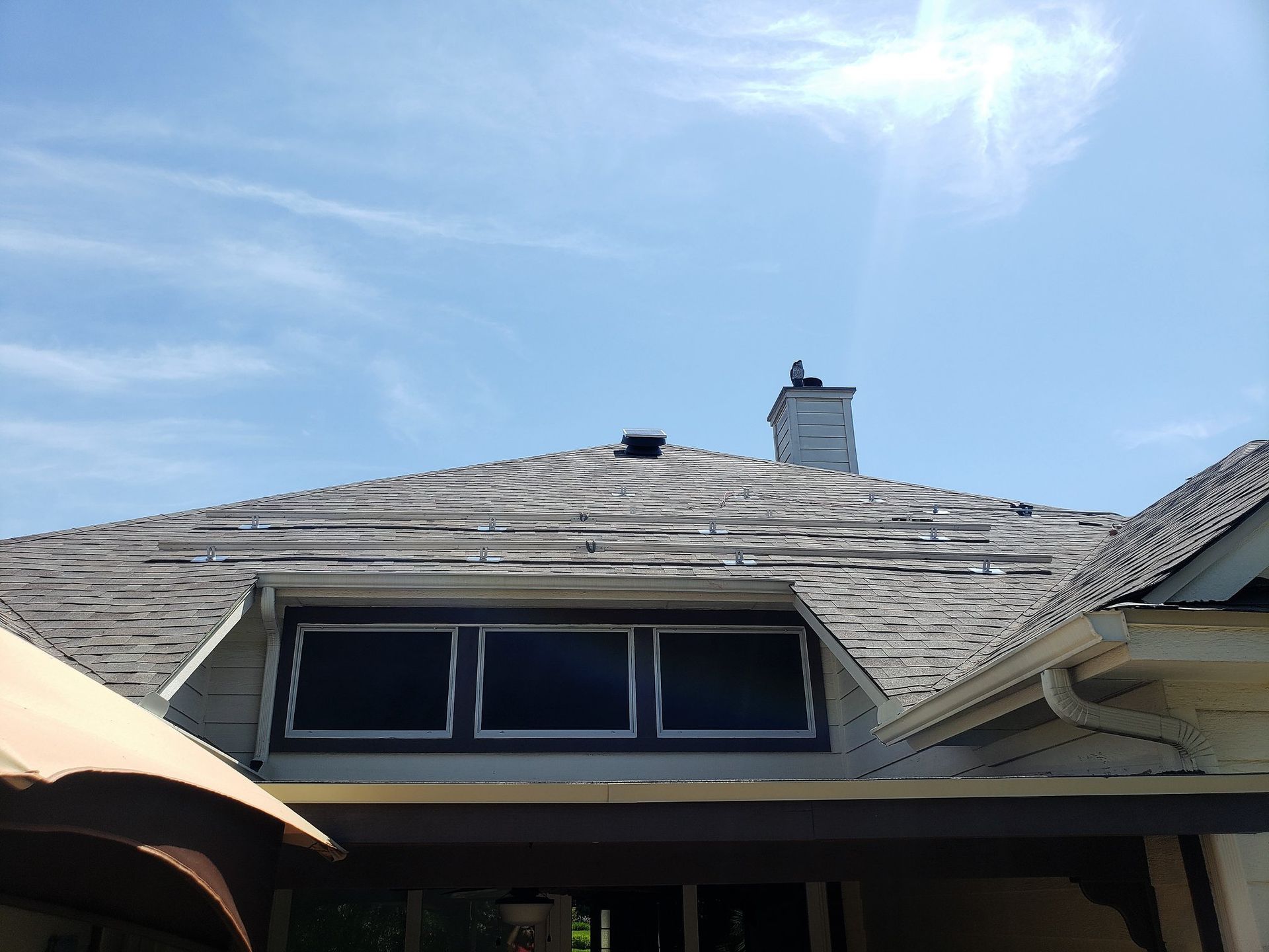 House roof with skylight windows under a bright blue sky