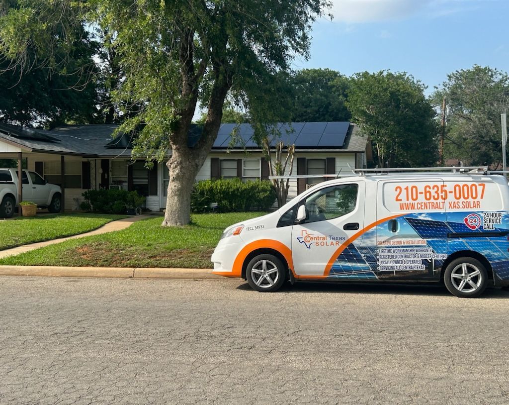 White-and-blue service van parked on a suburban street in front of houses and trees.