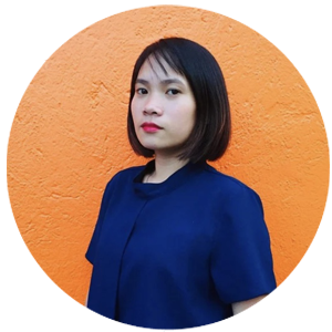 Portrait of a woman in a navy top against an orange wall