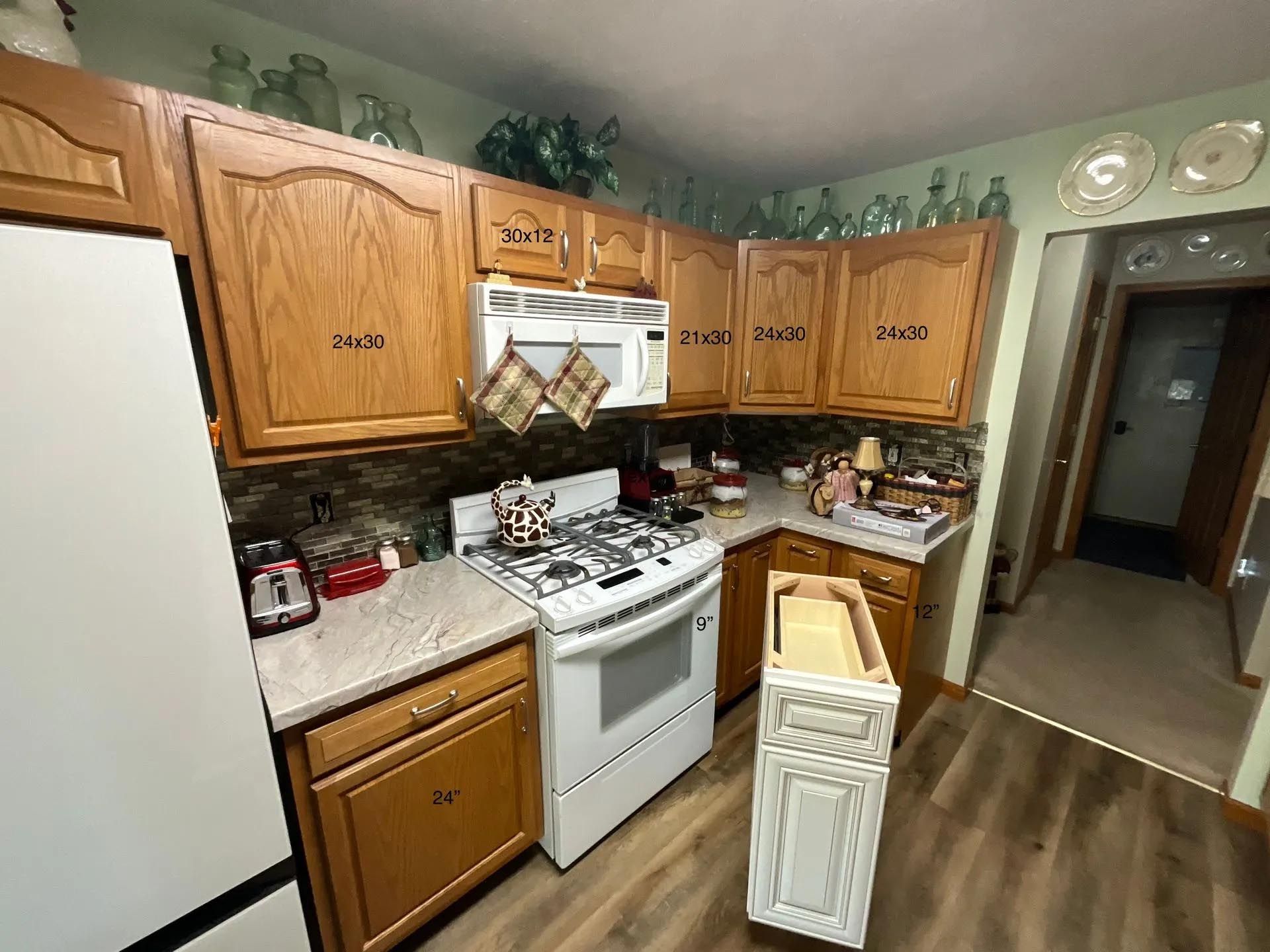 A kitchen with wooden cabinets , a stove and a refrigerator.