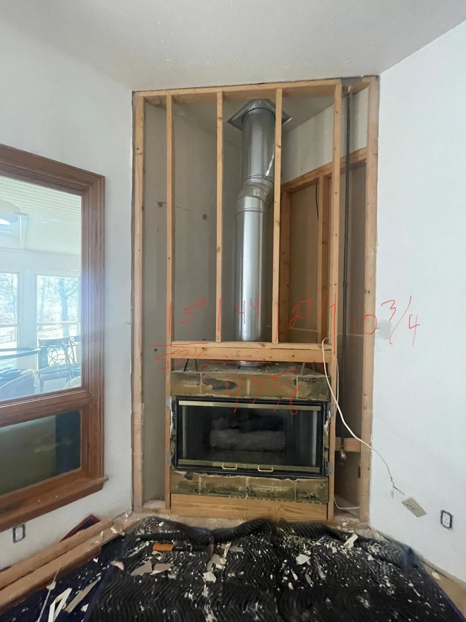 A fireplace is being built in the corner of a room.