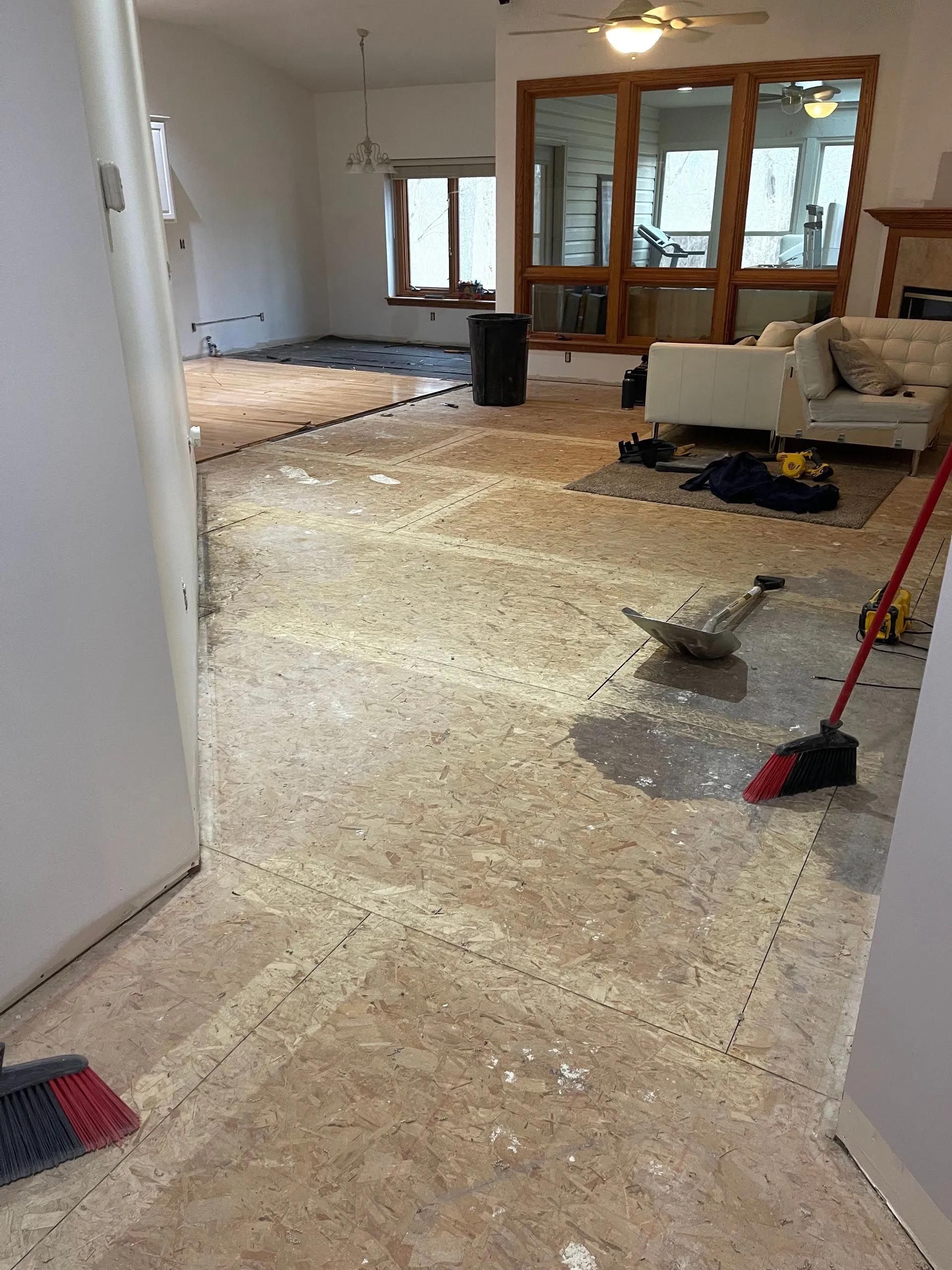 A living room with a couch and a broom on the floor.
