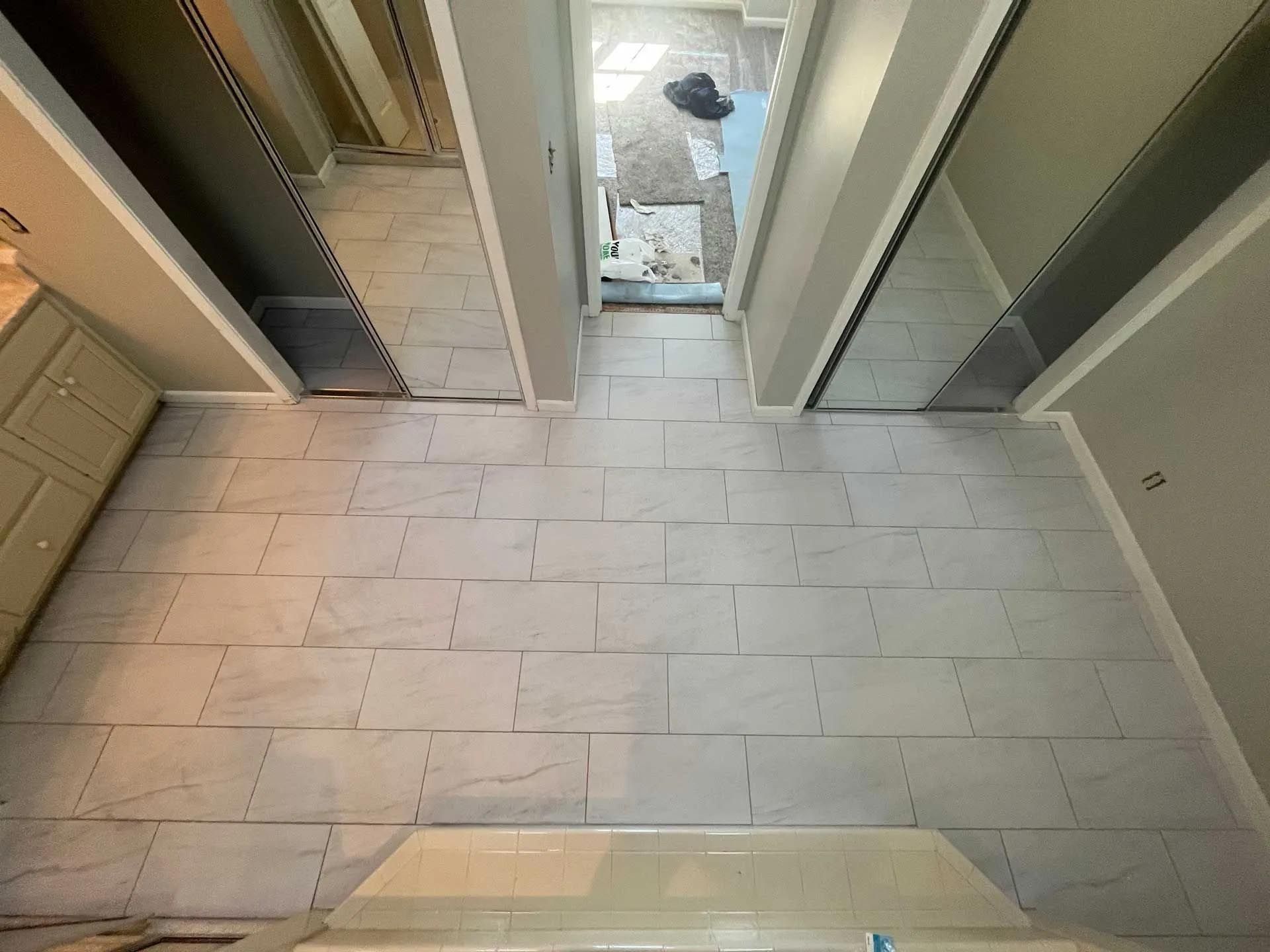 An aerial view of a hallway with tile floors and mirrors