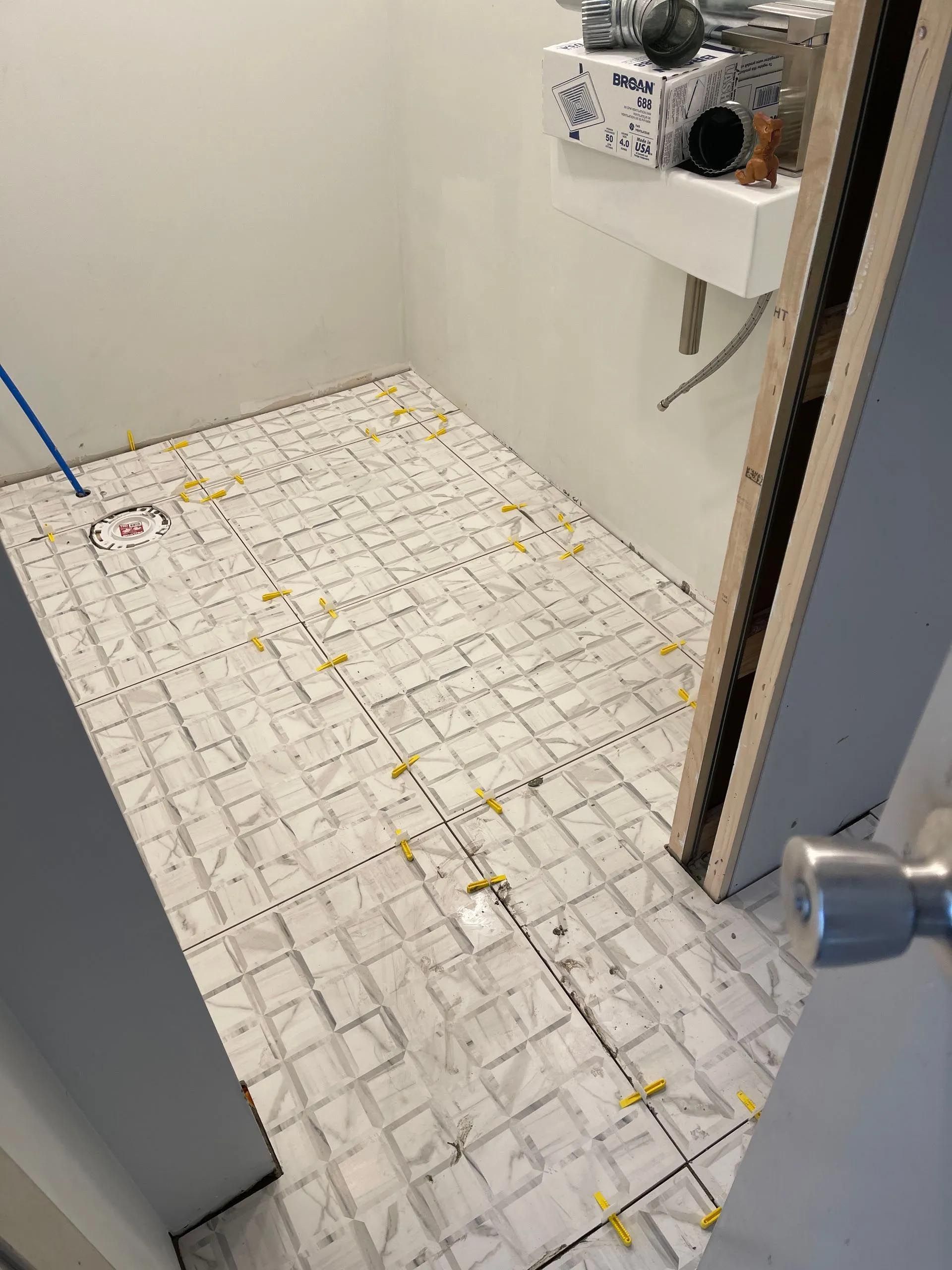 A bathroom with a tiled floor and a sink.