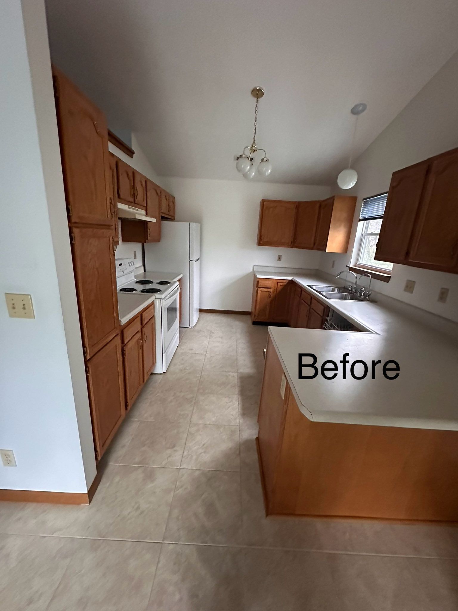 A before picture of a kitchen with wooden cabinets and white counter tops