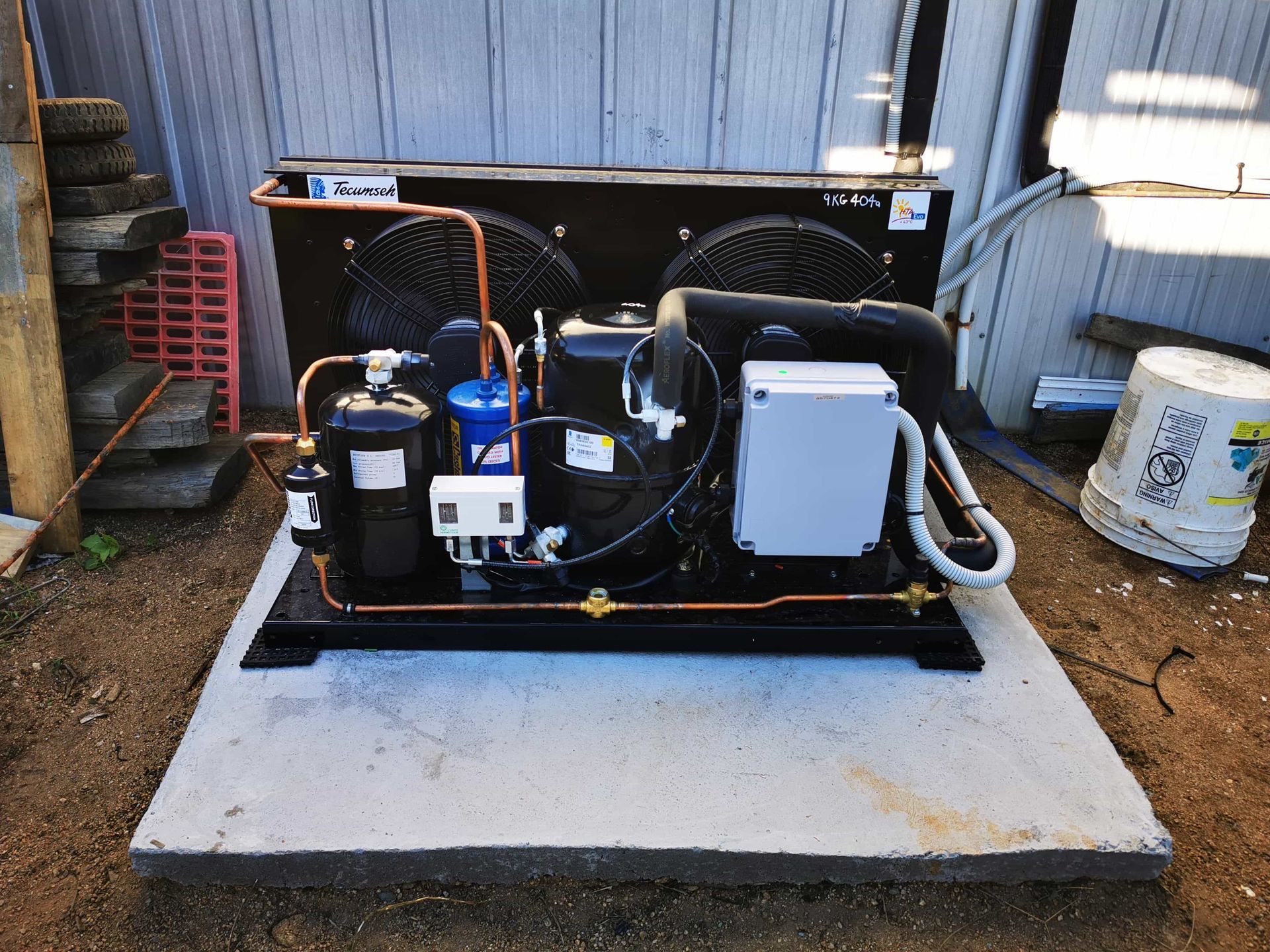 A machine is sitting on a concrete platform in the dirt. — Chillzone Refrigeration and Air Conditioning in Beerwah, QLD