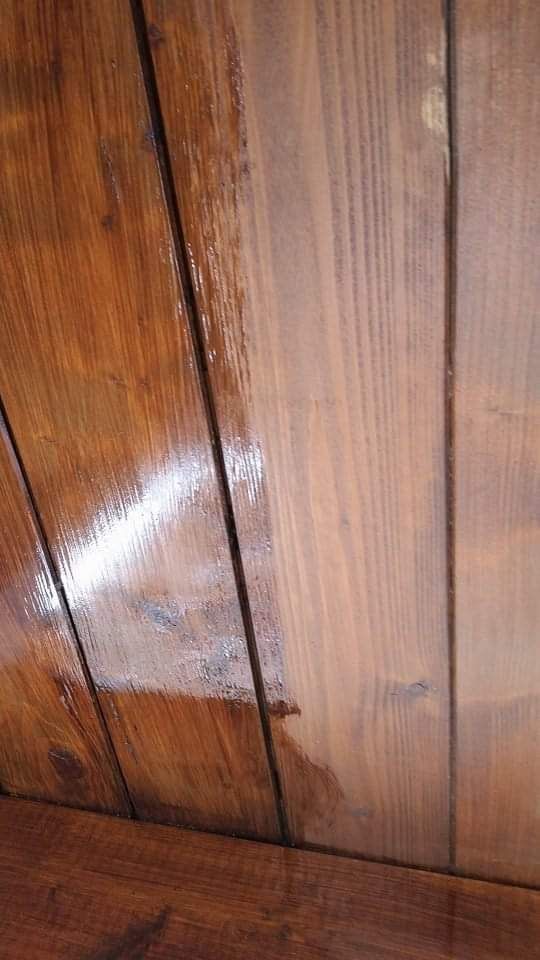 Primo piano di assi di legno lucide e verniciate, con una calda tonalità marrone.