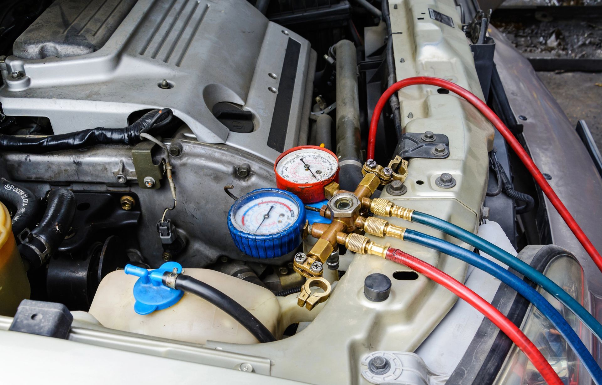 A close up of a car engine with gauges attached to it