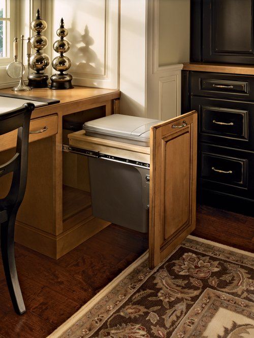 Pull-out cabinet with trash can in a kitchen setting. Light wood cabinet door and countertop. remodeling