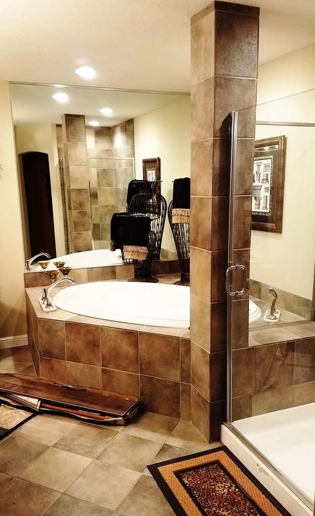 Luxurious bathroom with large jacuzzi tub, tile, and mirror.
