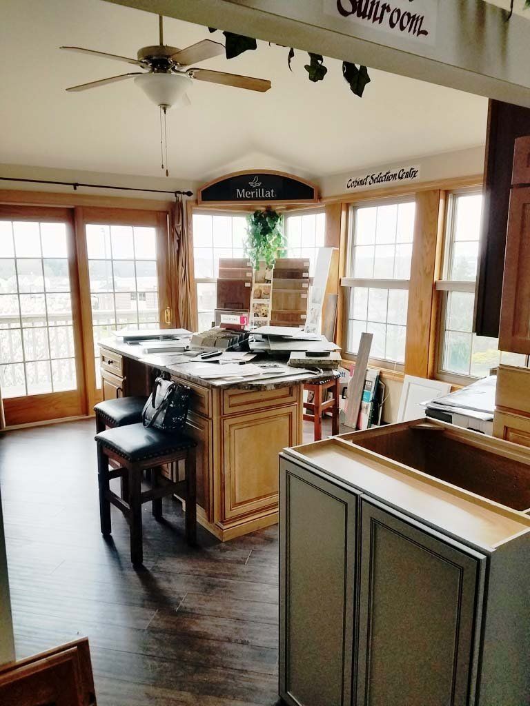Kitchen remodel: Island with stools, cabinets, windows, and unfinished work.