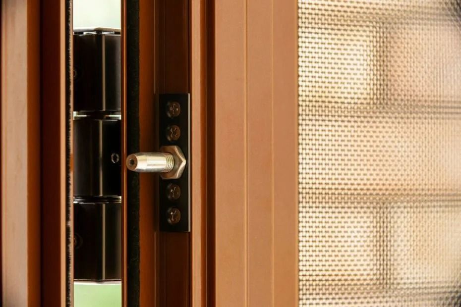 Brown security door with a metal lock and a mesh window.