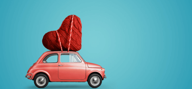 A red car with a heart on top of it.