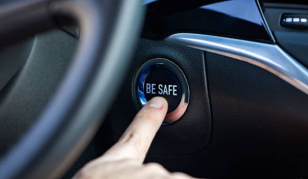 Finger pressing a car's start button that says