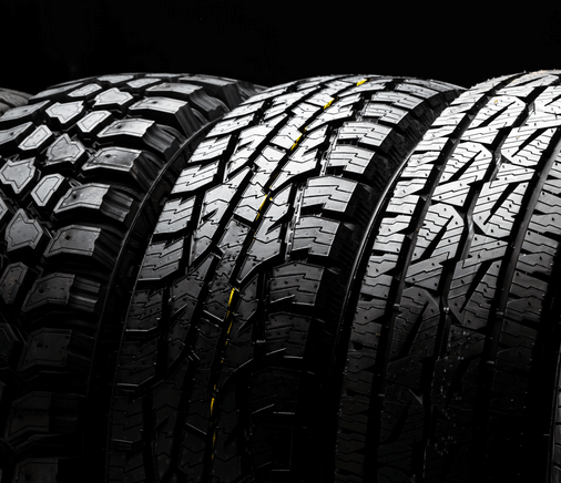 A close up of a stack of tires on a black background.