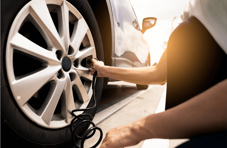 A person is pumping air into a car tire.